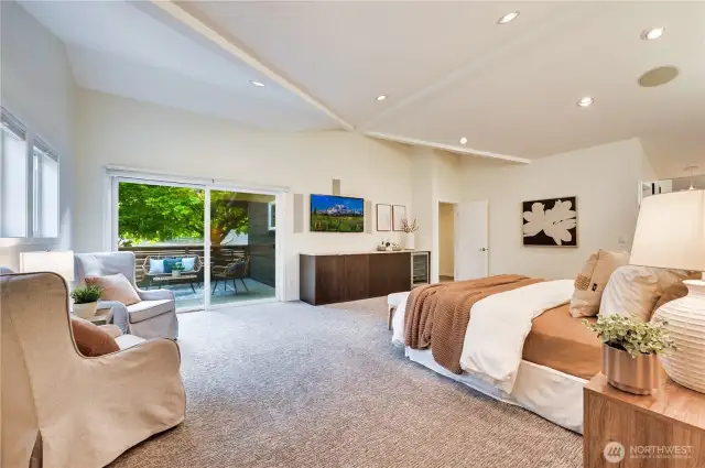 Here you can see the grand space with private patio and flat screen TV over built-in cabinetry with beverage cooler.