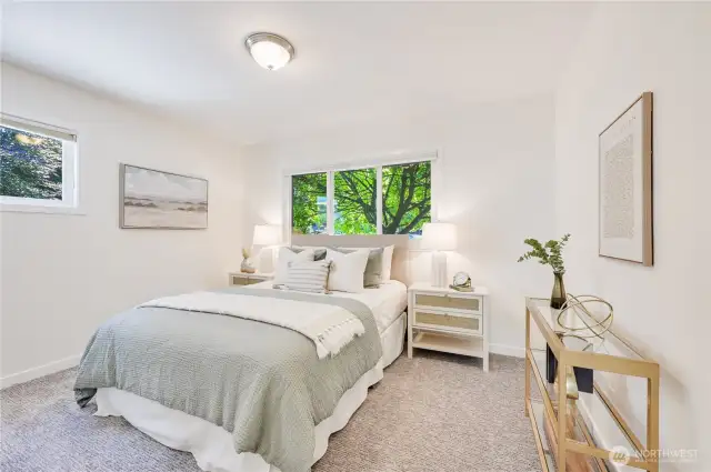 Lovely guest bedroom with lush treed outlook.