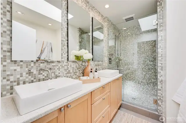 Gorgeous guest bath with tile and skylight.