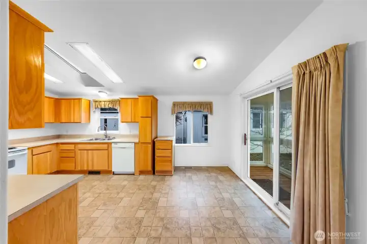 View from the Living Room to the open concept Kitchen, Dining and the sliding glass doors to the Sun Porch Area.