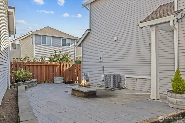 Low-maintenance backyard with patio and built-in firepit.