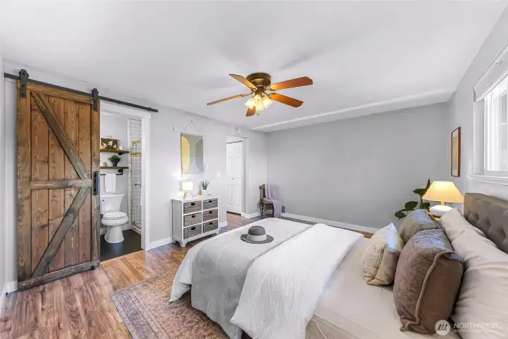 Barn door to the ensuite bathroom adds style and saves space