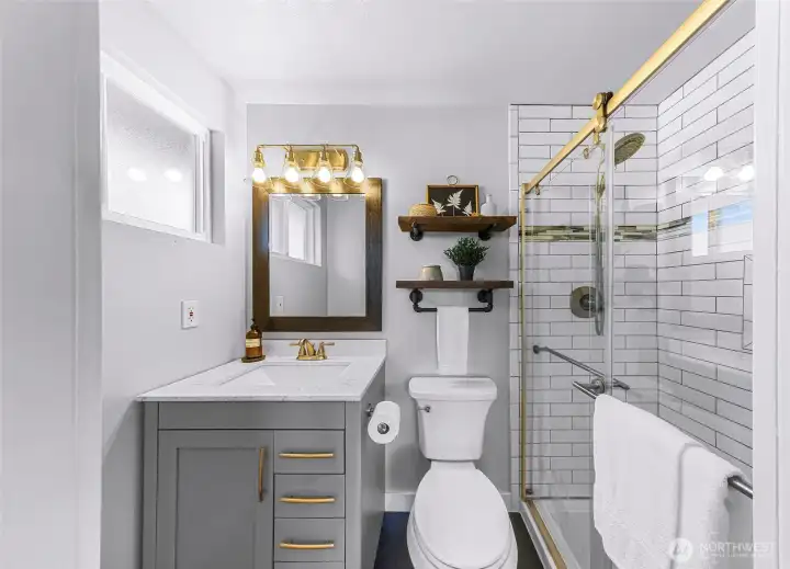 Updated primary bathroom with quartz countertop and tiled shower