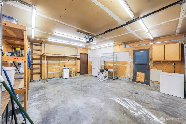 Large 2 car garage with door to side yard.  Second refrigerator and freezer included