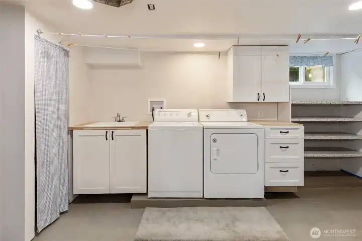 The basement has a large utility room with shelving for storage.