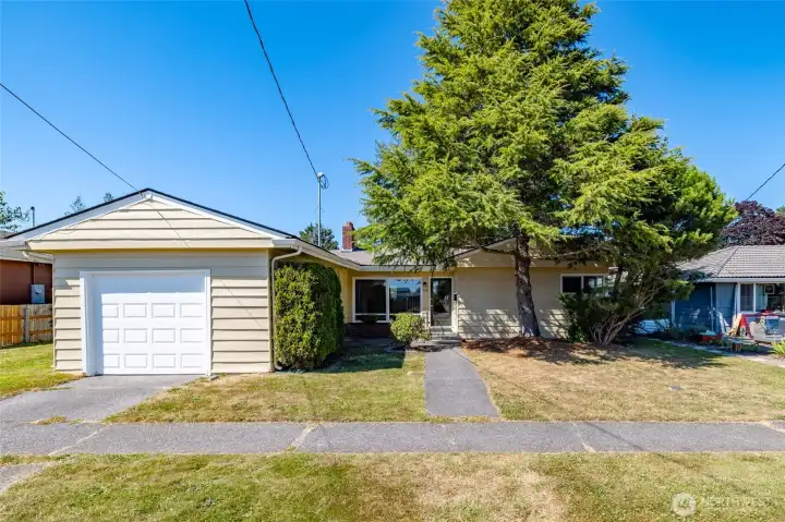 Fresh exterior paint, tidy yard, and an attached garage.