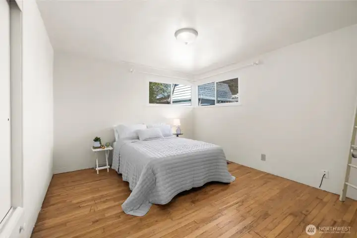 The second bedroom, nearly as large as the first, with built-in closet and drawers, hardwood floor.