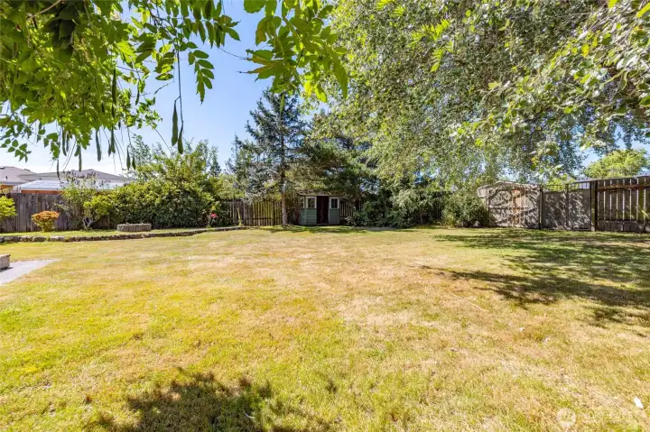Fantastic level, fenced back yard with alley access, mature trees, fire pit, and garden shed, and more.