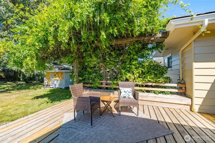 A generous deck off the back of the house offers plenty of space for family and friends when you want to entertain, and tucked in areas for smaller gatherings.  The adorable shingle-sided shed in the background could be for your garden tools, or use it as a playhouse.