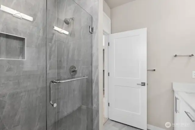 Sleek tiled shower in primary bathroom.