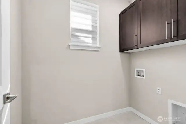 Top floor laundry with built in cabinets.