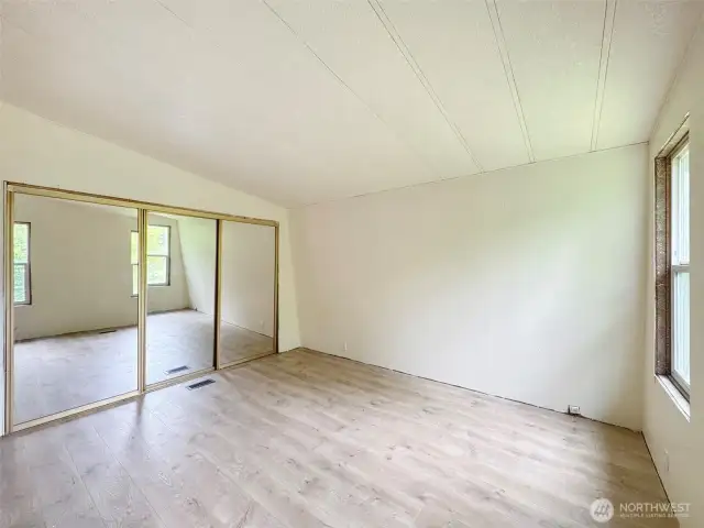 Primary showing the double closets and vaulted ceilings. Window needs the trim, one of few things to finish.
