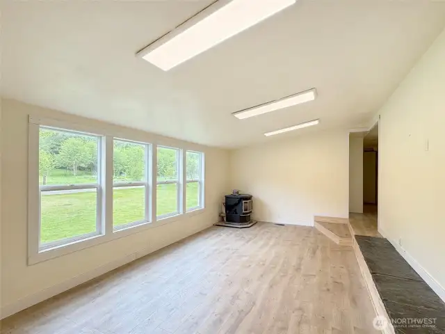 The living room from the front door, notice the step up to the hall area, or into the kitchen. Raised hearth on the right perfect for large screen TV.