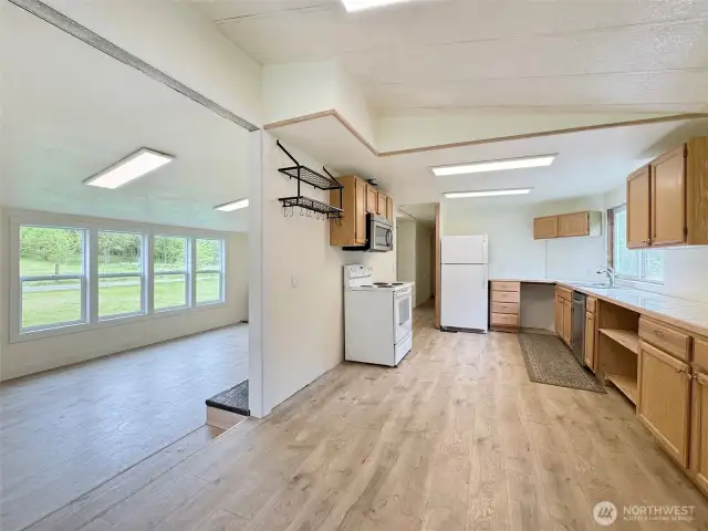 Kitchen from the dining area and step down to the living room.  room for more cabinets by the stove or bakers rack if desired.
