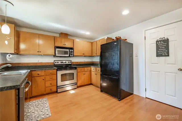 Kitchen with formica countertops and backsplash. Nice cabinet space.