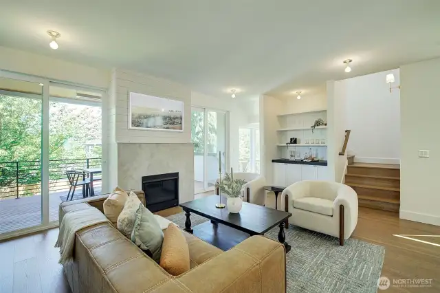 Family room with Samsung Art TV, fireplace, custom bar area with custom cabinets, soapstone counters and paneled walls, large windows and double doors leading to main floor patio, Rejuvenation light fixtures