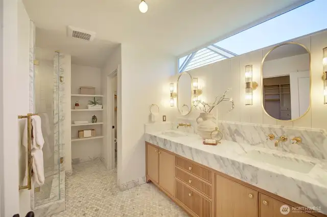 Primary bathroom featuring Italian Carrara marble, Zellige tile from AnnSacks, custom handmade cabinetry,  fixtures from Waterworks, large walk-in shower, Rejuvenation light fixtures, and heated floors