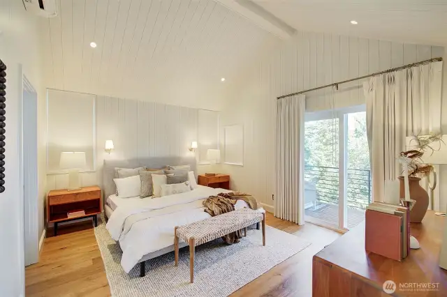 Primary bedroom with double door entrance to upper floor patio, paneled walls and ceilings, mini-split