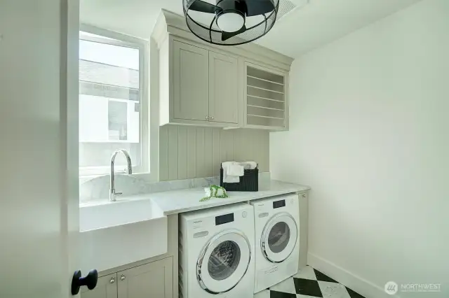 Laundry room with custom cabinetry, Ann Sacks Carrara marble counter and floor tiles, imported Miele washer and dryer, ceiling fan and large tub basin