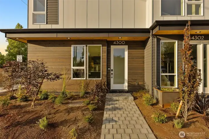 A warm welcome awaits with this thoughtfully landscaped front entry—modern lines meet lush touches in perfect harmony.
