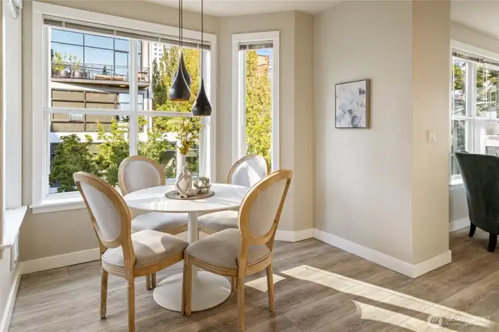 Beautiful sunlight pours into the dining area through windows on every side.