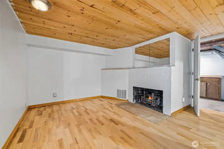 Downstairs second living area or family room with wood ceilings—solid potential for improvement.