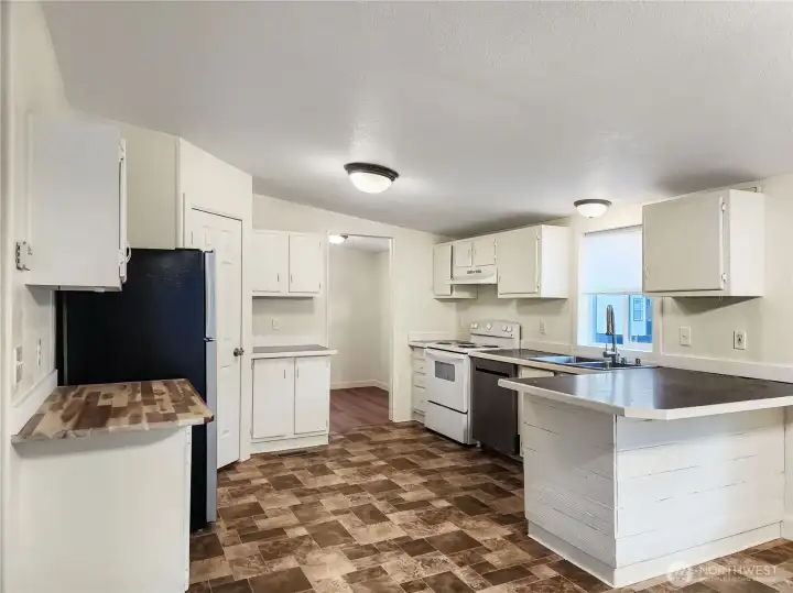 Ample counter prep space, eating bar, and walk-in pantry are features of this kitchen.