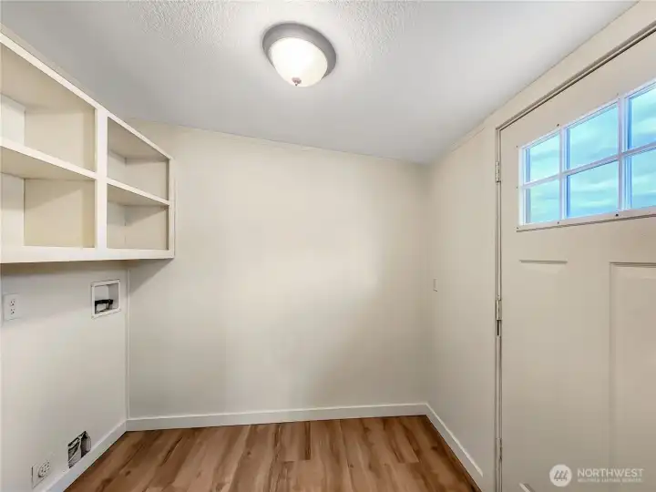 The laundry room has extra storage for laundry essentials with back-door access for convenience.