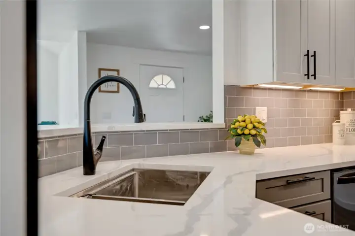 Deep under mounted sink with a sleek black  single-handle pull down sprayer faucet with turbo spray