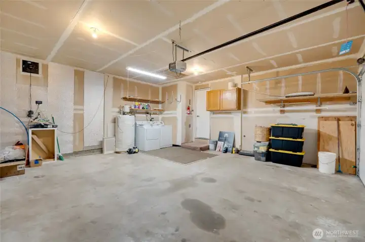 A spacious 2 car garage includes a dedicated laundry area with washer and dryer, offering added convenience and functionality.