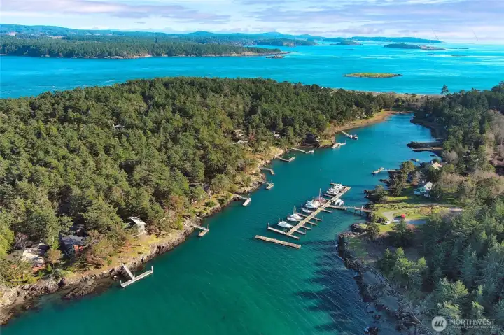 Expansive aerial highlighting the protected marina basin, surrounding homes, and natural beauty that define this desirable Cape San Juan neighborhood.