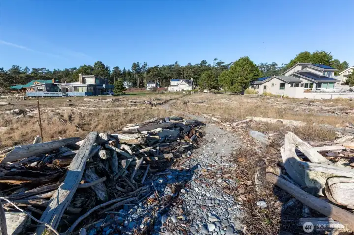 Natural beach access path leading back toward nearby residences, highlighting the connection between community living and waterfront access.