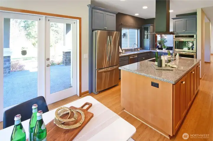 The breakfast nook adjoins the kitchen. French doors open to the covered patio for easy hosting from the kitchen to your guests. Note the beautiful bamboo flooring throughout the home.
