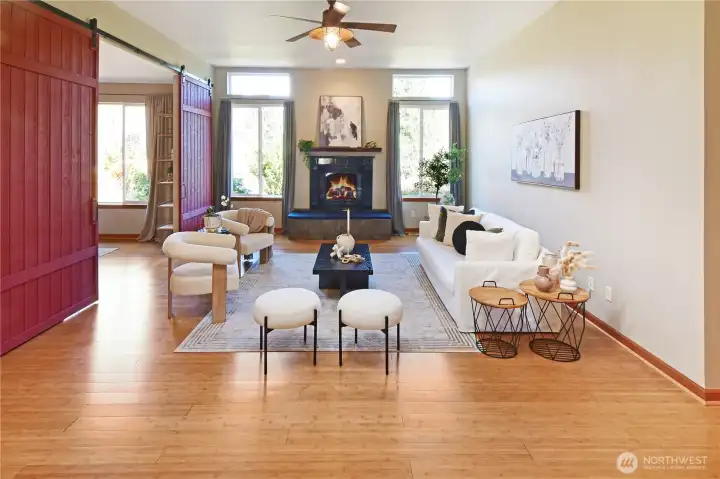 Spacious living room with cozy fireplace, abundant natural light, and wide-open layout for effortless single-level living. The barn doors add a modern designer feature. Close off the dining room or keep it open as you wish.