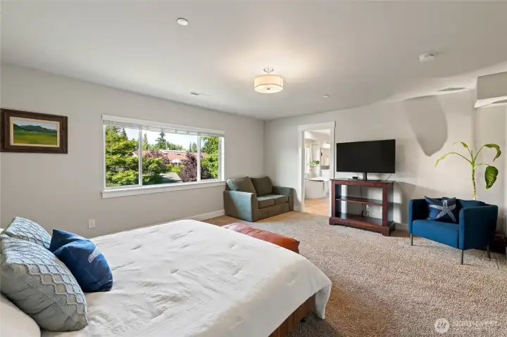 Primary on-suite bath with a separate, deep tub is through the doorway.
