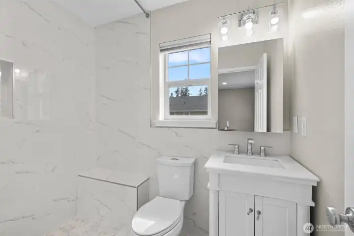 The primary bathroom has also been remodeled with a timeless, neutral palette. The step-in shower is spacious!
