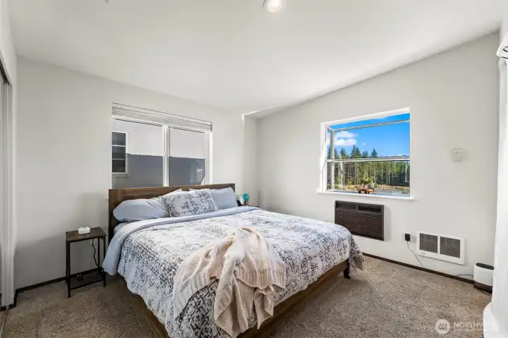 Sun-filled primary bedroom with south-facing windows, peaceful natural light & a relaxing retreat-inspired atmosphere Sun-filled primary bedroom with south-facing windows, peaceful natural light & a relaxing retreat-inspired atmosphere