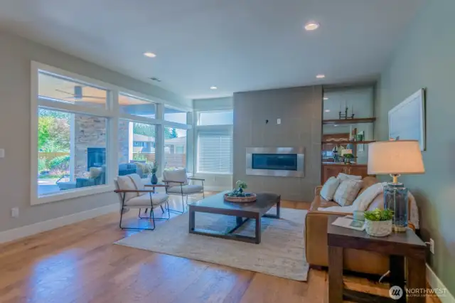 Expansive windows flood the great room with light and views to the backyard oasis
