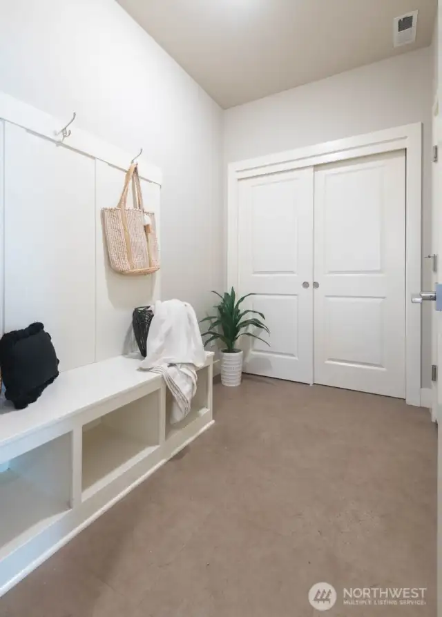 Mudroom with ample storage connects to the spacious 2 car garage
