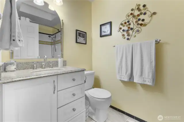 Full main bath with granite counters marble floors jetted tub with tile surround.