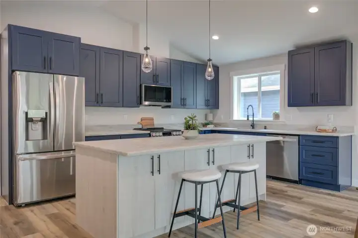 Whitwashed island with storage cabinets on both sides and plenty of room for seating