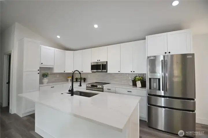 Beautiful kitchen boasts large island, stunning backsplash & SS appliances.