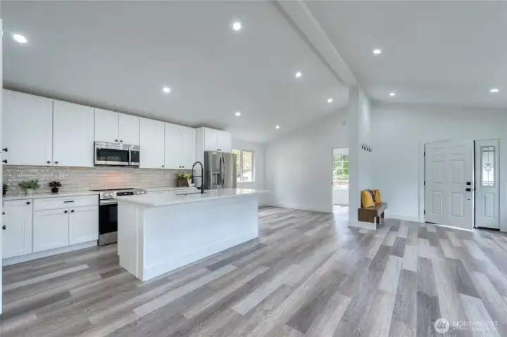 OPEN CONCEPT living ~ notice the handy built-in bench seating with coat racks. Opening to front bonus/flex room ~ a light space ready to make into a home office or whatever suits your lifestyle.