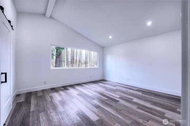 Primary bedroom showcases peaceful views of the trees and river.