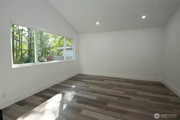 Bdrm #3 ~ Bright & cheerful primary suite with a large window framing the backyard and river.