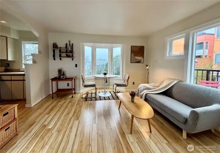 Living room with bay window looking west to Downtown.  Notice the beautiful flooring throughout the condo.