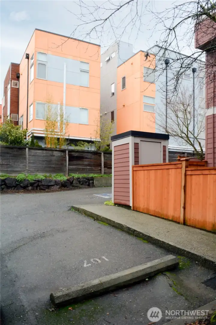 Parking space is steps from the front door of the unit. Yard behind the new cedar fence is solely for this unit, with a storage shed that is shared with a neighbor.