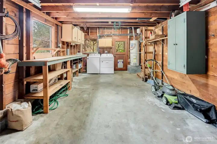 One car Garage with work bench, cabinets and laundry. ladder on the left leads to a large garage attic storage space.