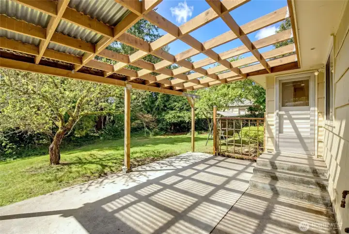 This enhanced photo shows what it could look like if a new owner prefers an open pergola instead of the existing covered patio.
