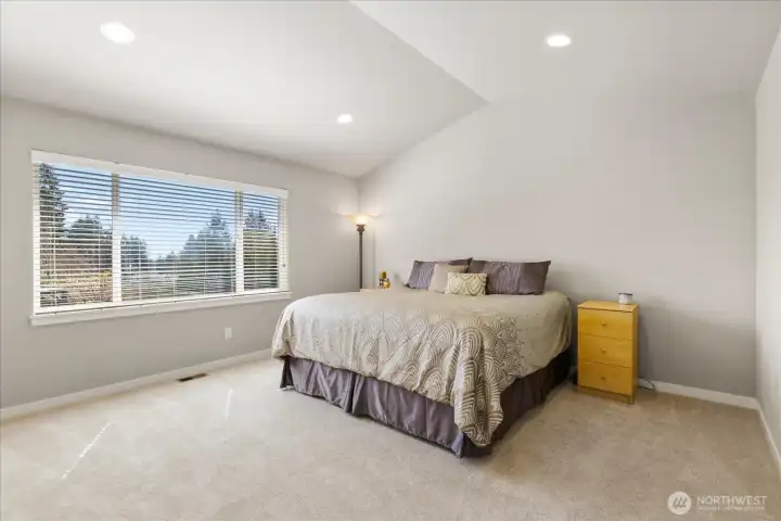 Primary bedroom with double door entry and vaulted ceilings